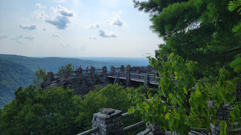 An overlook surrounded by stone and metal rails is in the distance