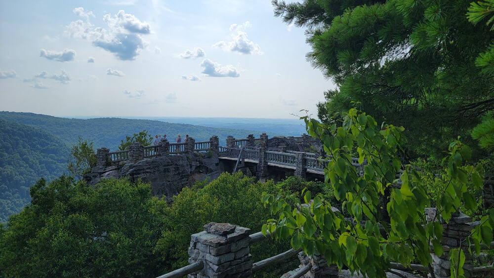 An overlook surrounded by stone and wooden rails is in the distance
