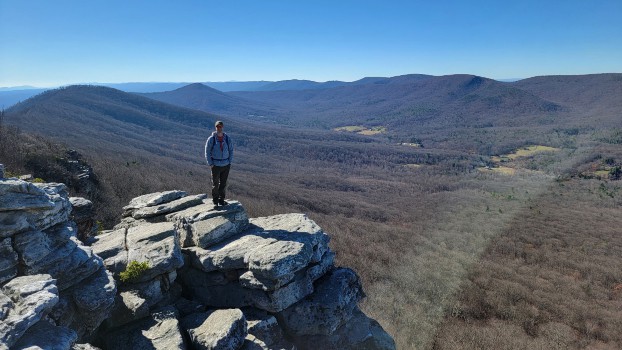Man stands on rock with West Virginia in the background
