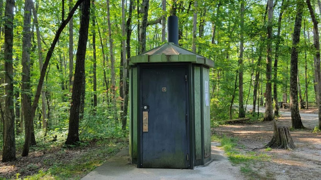 Building structure with a vault toilet inside at Grays Arch in Red River Gorge