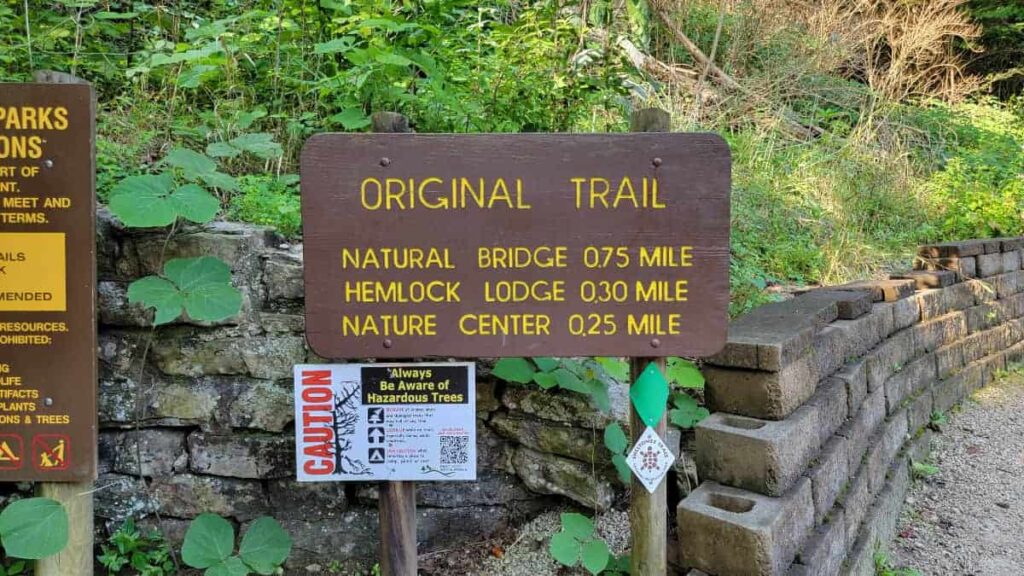 Trailhead sign reading "Original Trail" and "Natural Bridge .75 mile, Hemlock Lodge .3 mile, and Nature Center .25 mile"