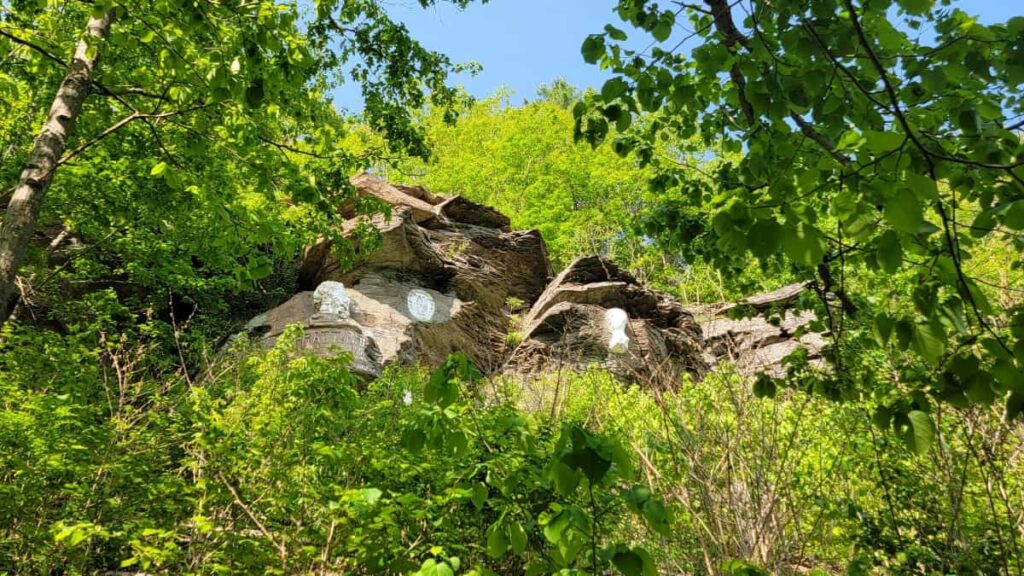 View of stone carvings at Pratt Rock through the tree from a low viewpoint