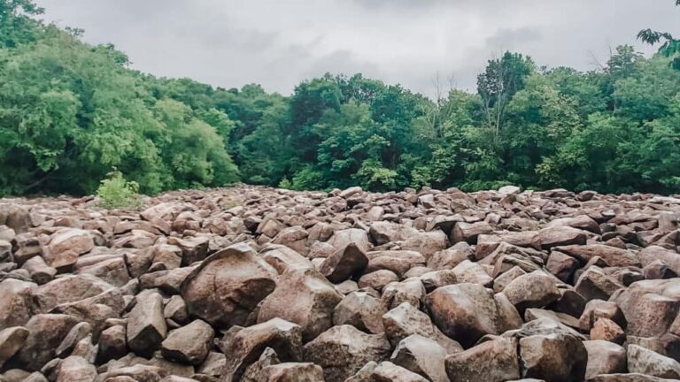 A large boulder field with trees behind at Ringing Rocks County Park in Bucks County