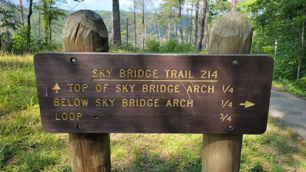 trail sign reading "sky bridge trail 214" and "Top of sky bridge arch 1/4; below sky bridge arch 1/4; loop 3/4"