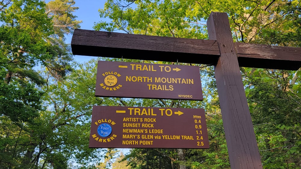 Trail sign for North Mountain Trails, with distances to Artist's Rock, Sunset Rock, and Newman's Ledge written on the sign