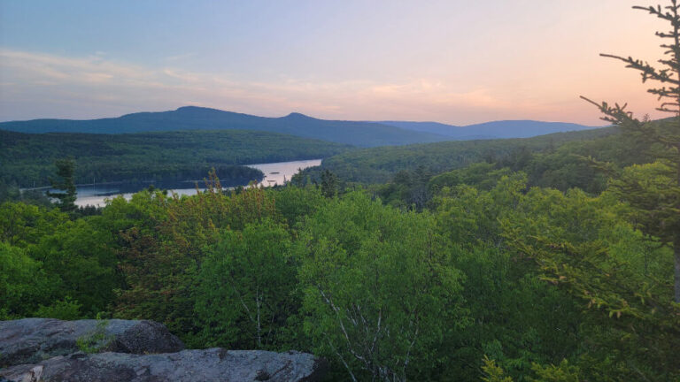 View of the sunset and lake with mountains in the background