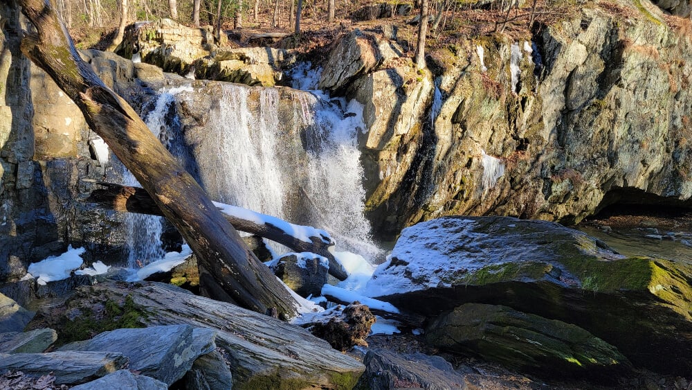 A waterfall with rocks and snow at the base - Kilgore Falls is Maryland's second tallest waterfall