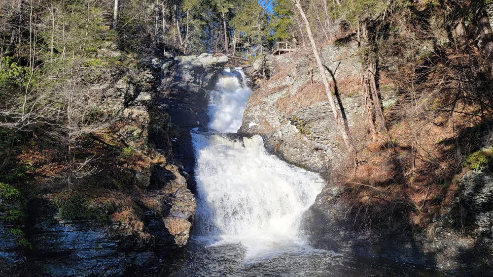 A full, two level waterfall empties into a large pool in winter at the Delaware Water Gap