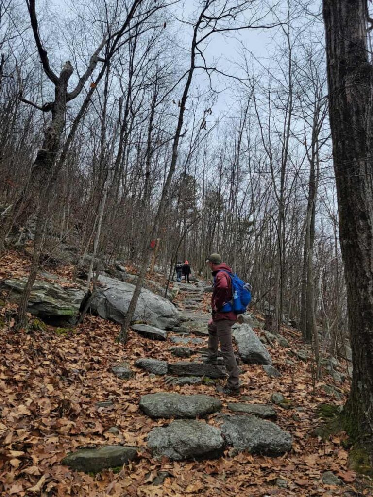 A man looks up at two young kids as they climb up stone steps on Glen Onoko trail