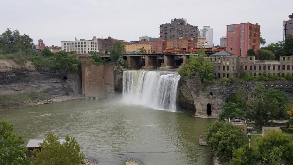A train rides on the track that passes over High Falls in Rochester