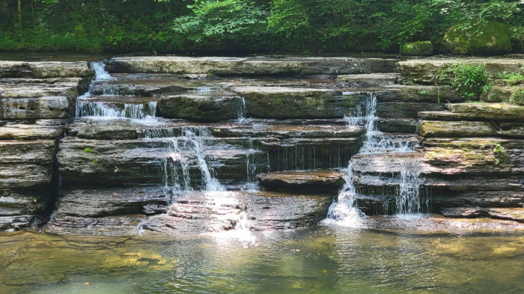 View of Campbell Falls in Camp Creek State Park with low flow water and a pool at the base