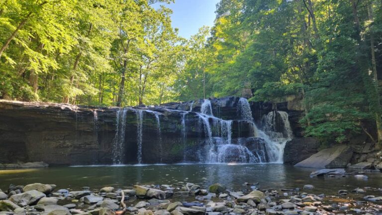 view of Brush Creek Falls from the base with a pool and rocks in the foreground