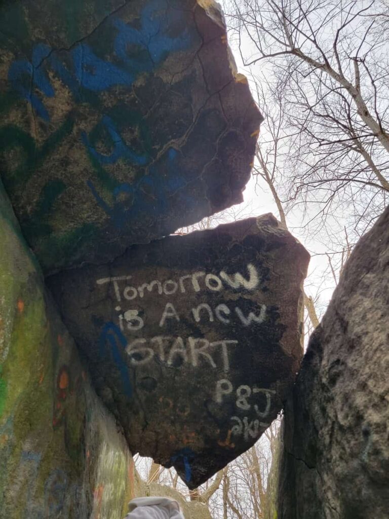 a spray painted message on a large boulder reads "tomorrow is a new start"