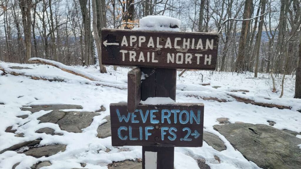 A wooden sign points to the Appalachian Trail towards the left and the Weverton Cliffs to the right