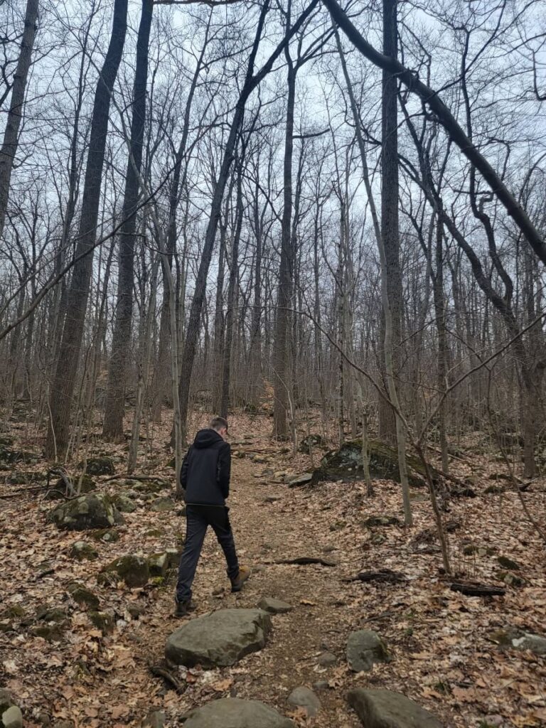 a boy hikes on a trail in winter