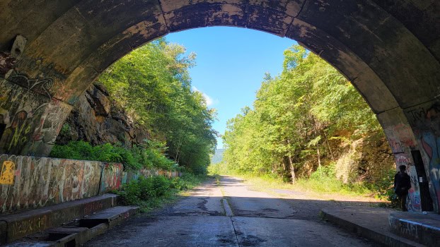 view looking out of an abandoned pa turnpike tunnel towards the road