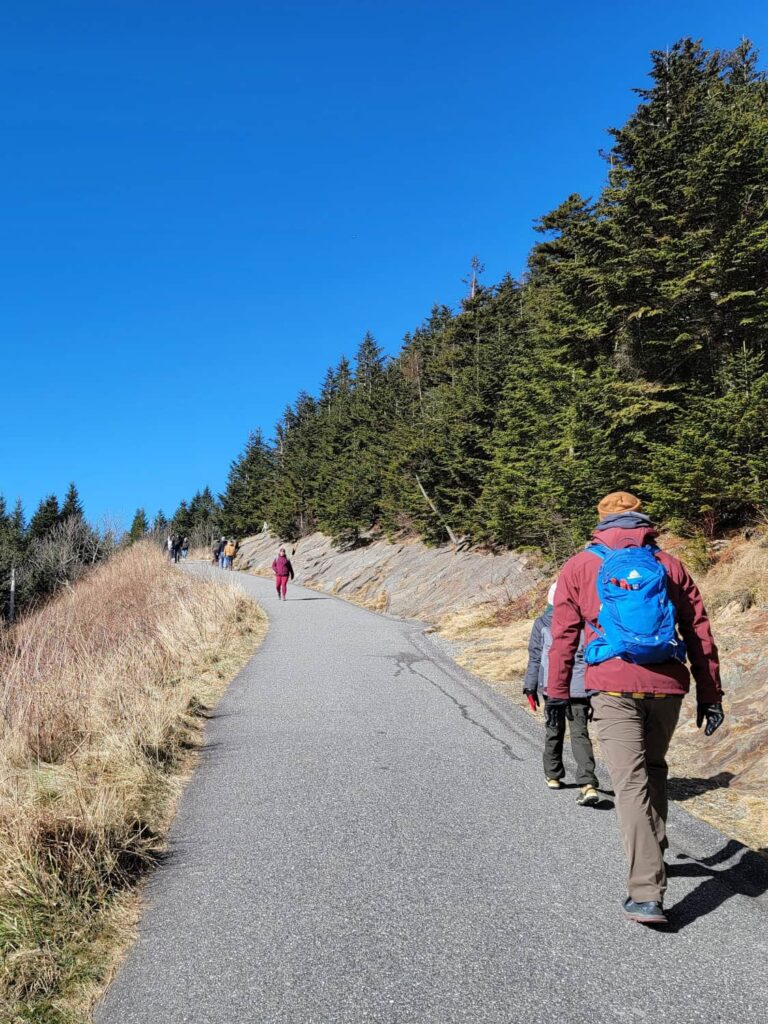 A man walks up a steep paved trail at Kuwohi Clingmans Dome