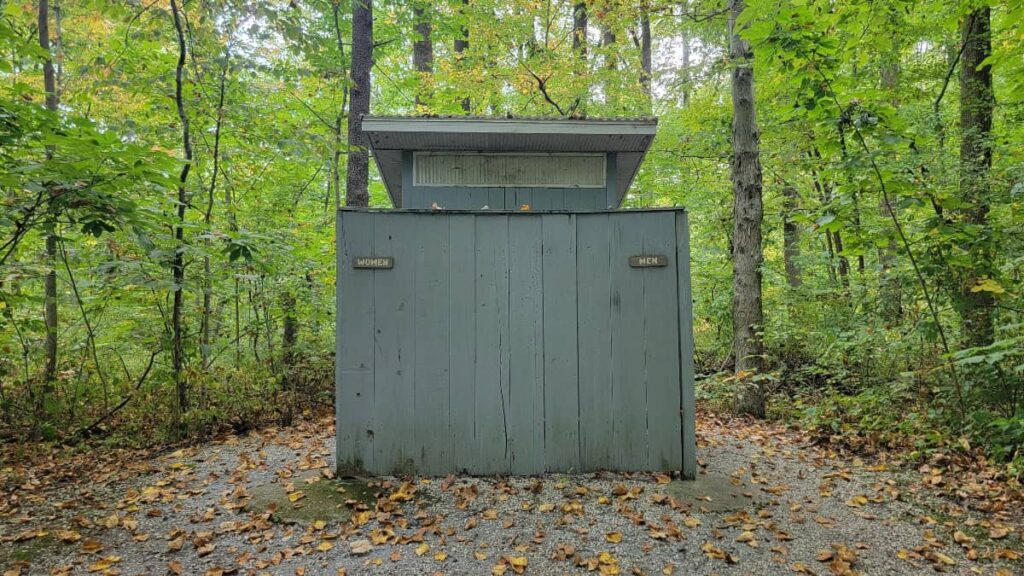 A grey wooden building holds two vault toilets a Monocacy Hill in Douglasville, PA