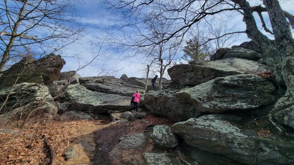 a young girl walks towards large rocks at the Chimney Rocks overlook in Michaux State Forest