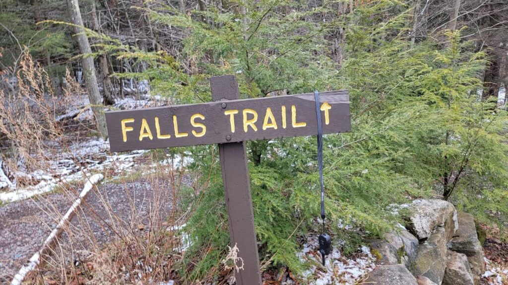 A wooden sign reads "Falls Trail"