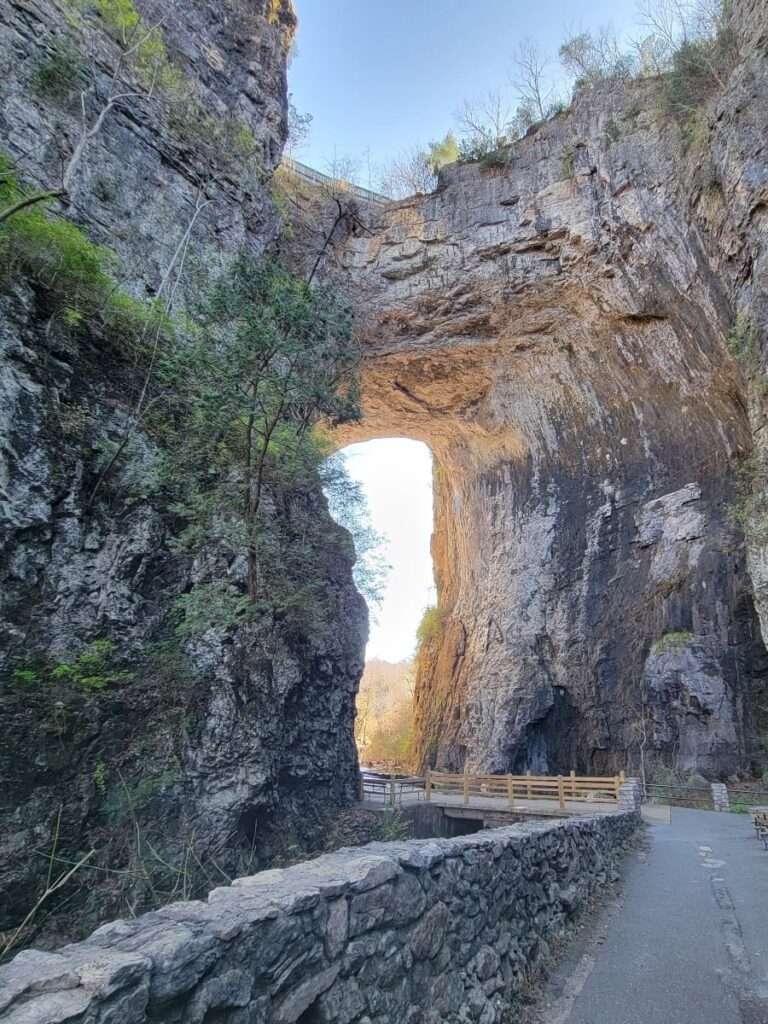 Looking at a stone arch with a paved path going underneath