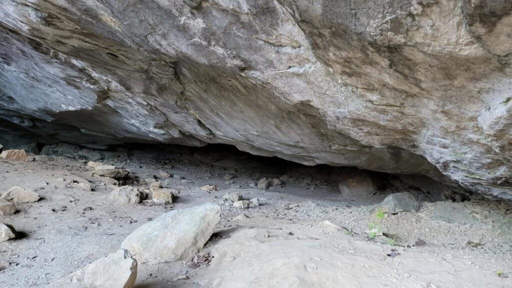 A narrow entry to a cave is almost parallel to the ground