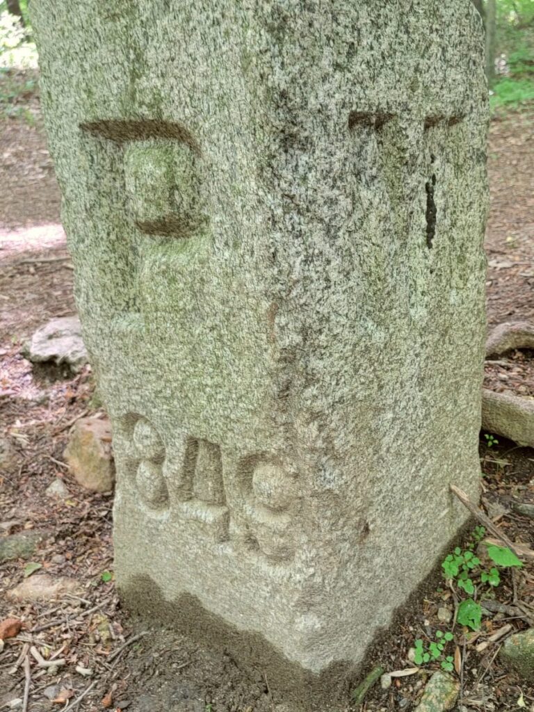 A stone market is engraved with the letter P on one side and M on another