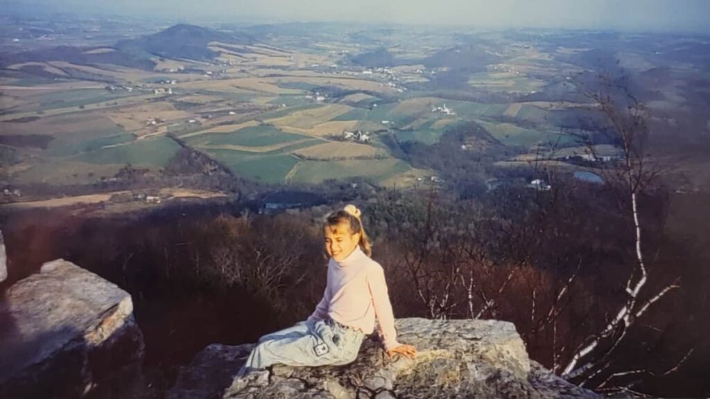 A young girl sits on a rock at the Pinnacle Overlook on the Appalachian Trail in Pennsylvania