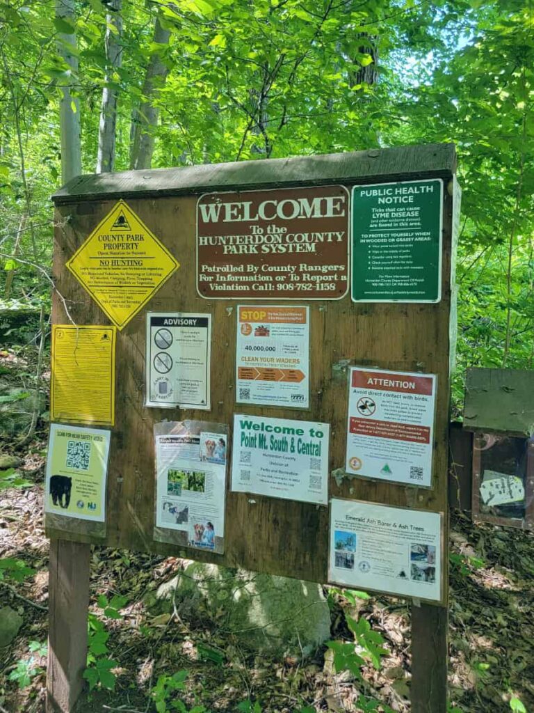 A trailhead sign with various postings on at Point Mountain