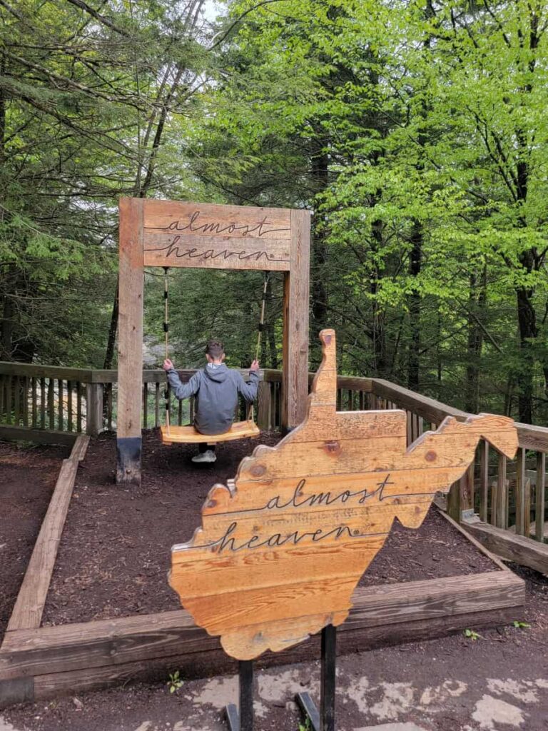 A teenage boy sits on the Almost Heaven Swing overlooking Blackwater Falls