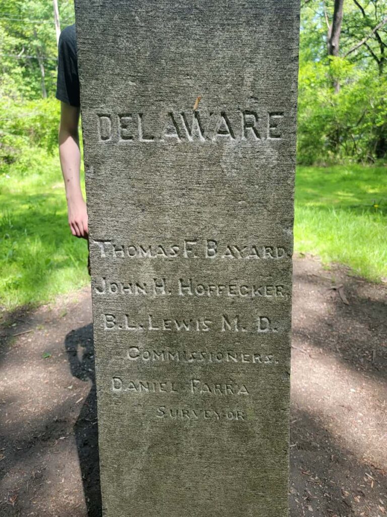 A stone pillar is engraved with "Delaware"