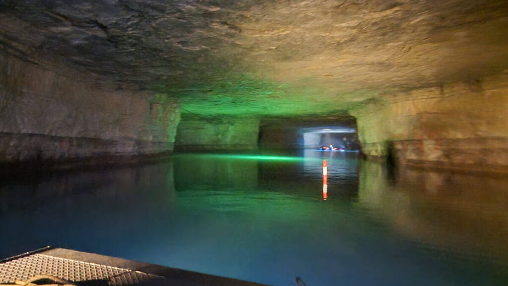 An old mine is filled with water and lit up for a boat ride