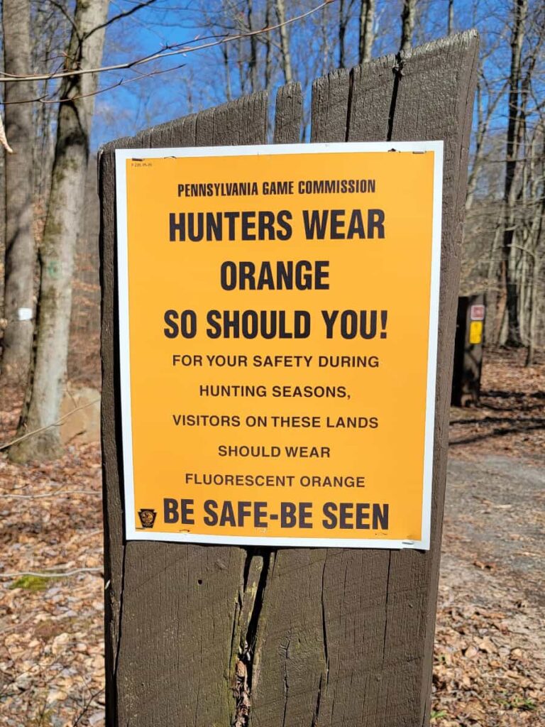 A sign reads "Hunter wear orange, so should you"