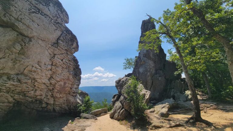 A large triangular rock juts up at the top of Cover Mountain on the Dragon's Tooth Trail