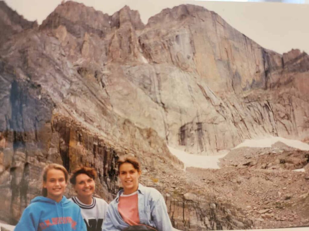 A mother and her daughters stand with Long's Peak in the background