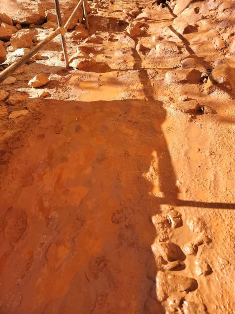 the dirt on the paved path at Lower Pools becomes muddy from the waterfall spray