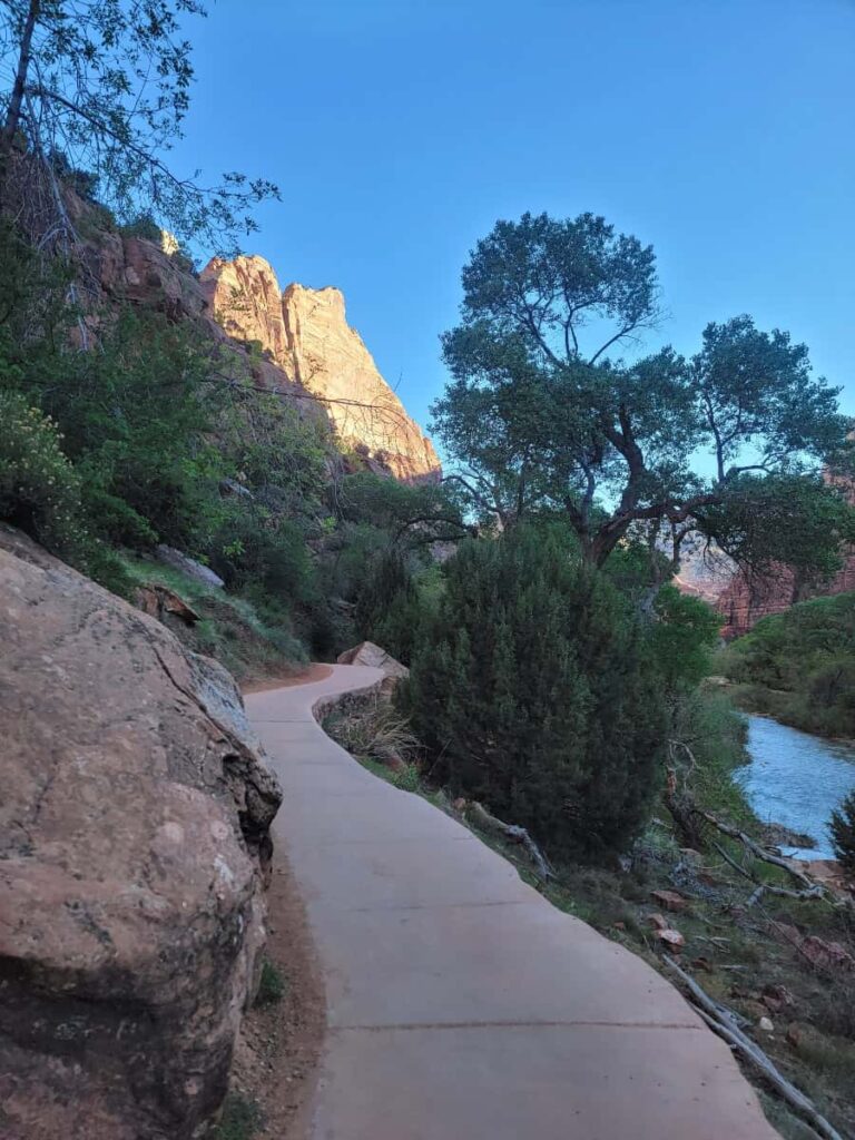 A paved path meanders along side a canyon rockface