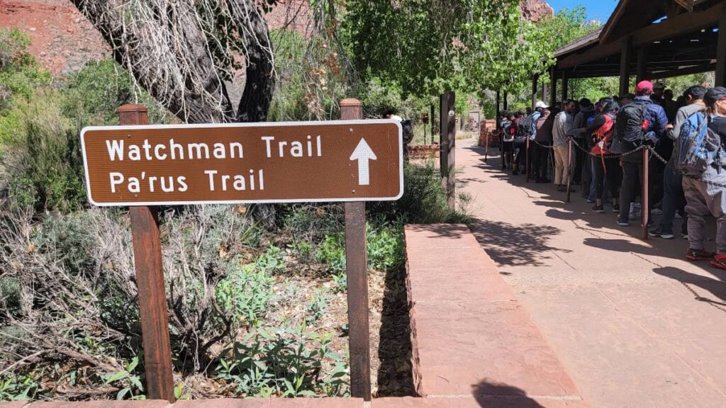 A sign points in the direction of the Watchman Trail and Pa'rus Trail at the Zion Visitor Center