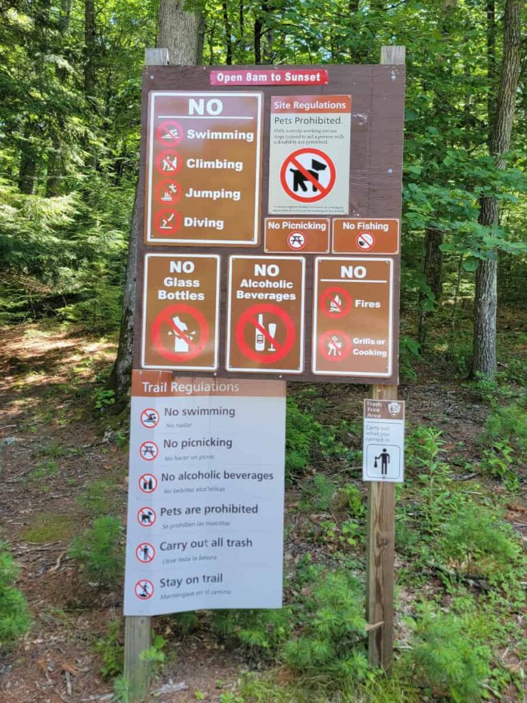Multiple signs show the rules of visiting George W Childs Park