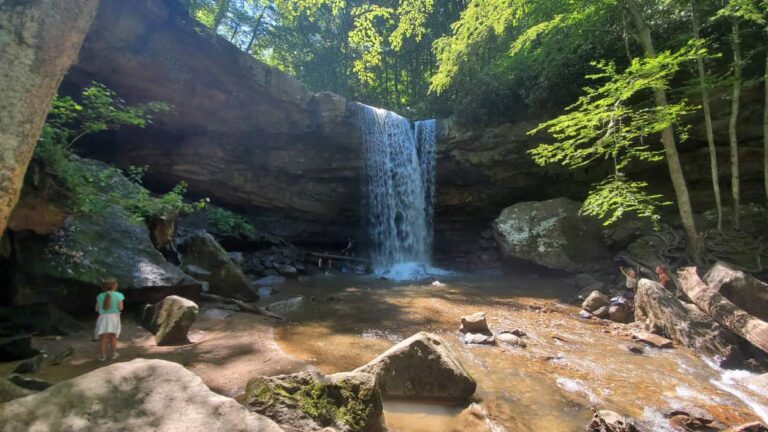 A young girl stands to the side and looks at Cucumber Falls in Ohiopyle State Park