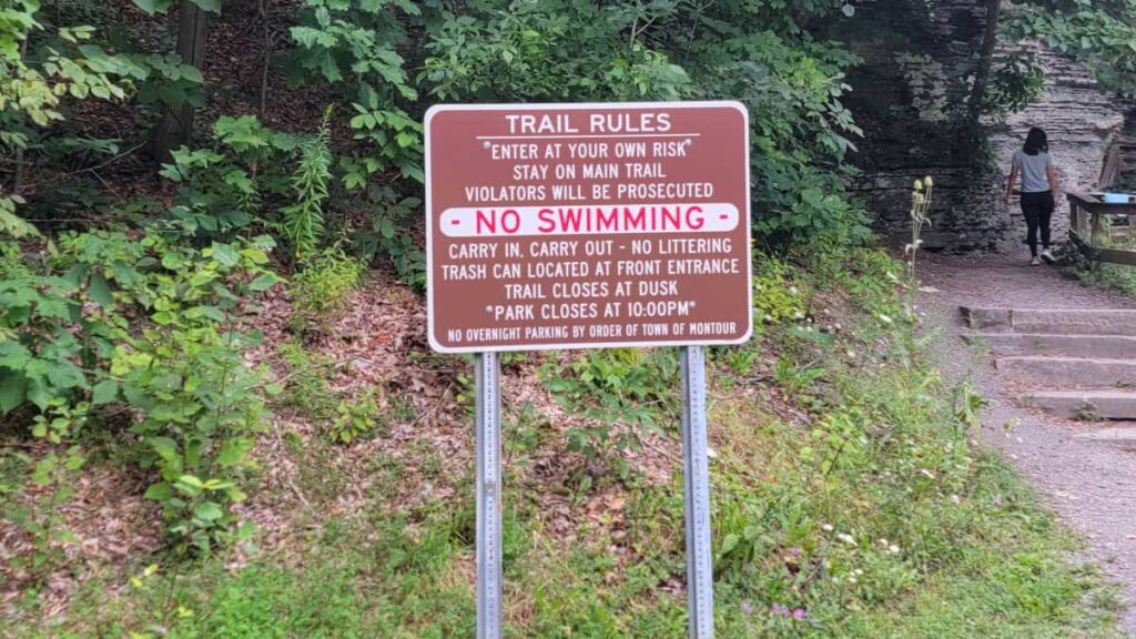 A sign at the start of the Eagle Cliff Falls trails shares trail rules including no swimming