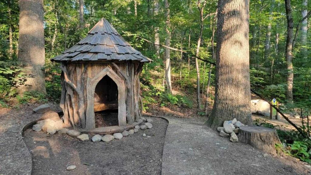 A cute hobbit house is made for kdis to explore inside the arboretum at James Madison University