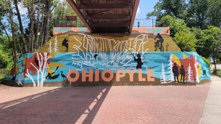 A mural for Ohiopyle is painted on a wall beneath the Greater Allegheny Passage