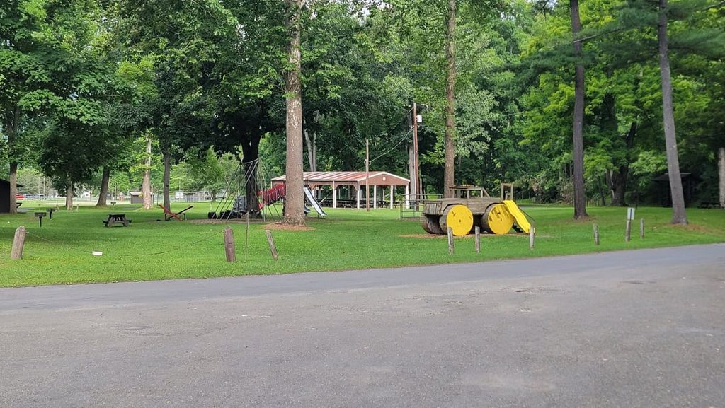 A playground with swings, metal slides, monkey bars and more sits next to the parking lot for Eagle Cliff Falls