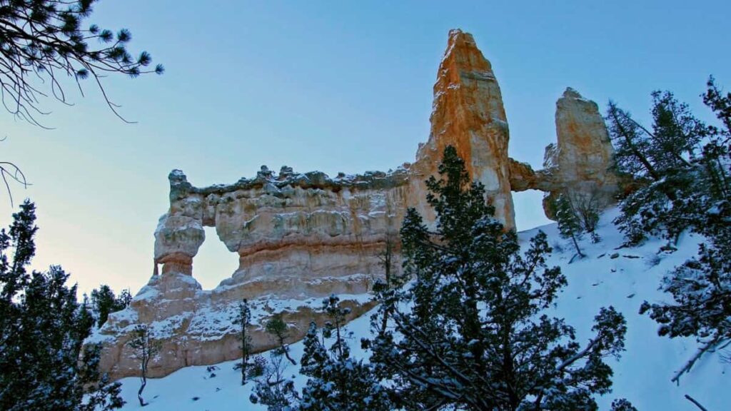 Hoodoos at Bryce Canyon form a bridge with snow covering the ground
